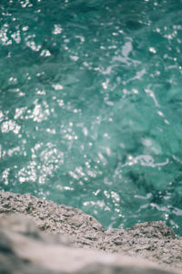 blue sea bubbling below the grey hard stones blue sea bubbling below the grey hard stones